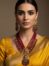 Woman wearing a yellow saree with intricate jewelry on a brown background